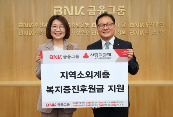 (사진: BNK금융그룹 정성재 그룹경영지원부문장(오른쪽)이 15일 본사에서 부산사회복지공동모금회 장보임 사무처장에게에 후원금을 전달하고 있다.)