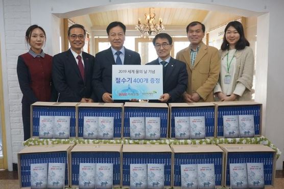 (사진: BNK저축은행 성명환 대표(왼쪽에서 세번째)가 초록우산어린이재단 부산종합사회복지관에 절수기 400개를 전달 후 기념촬영을 하고 있다.)